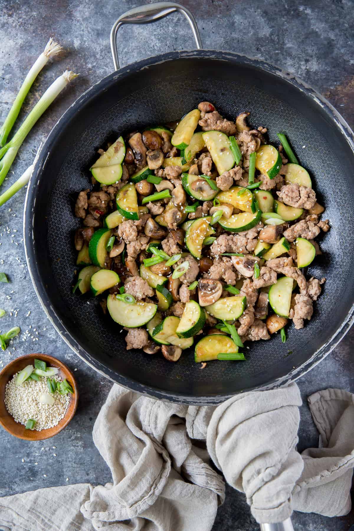 The ground pork stir fry in a large skillet shot from over the top.
