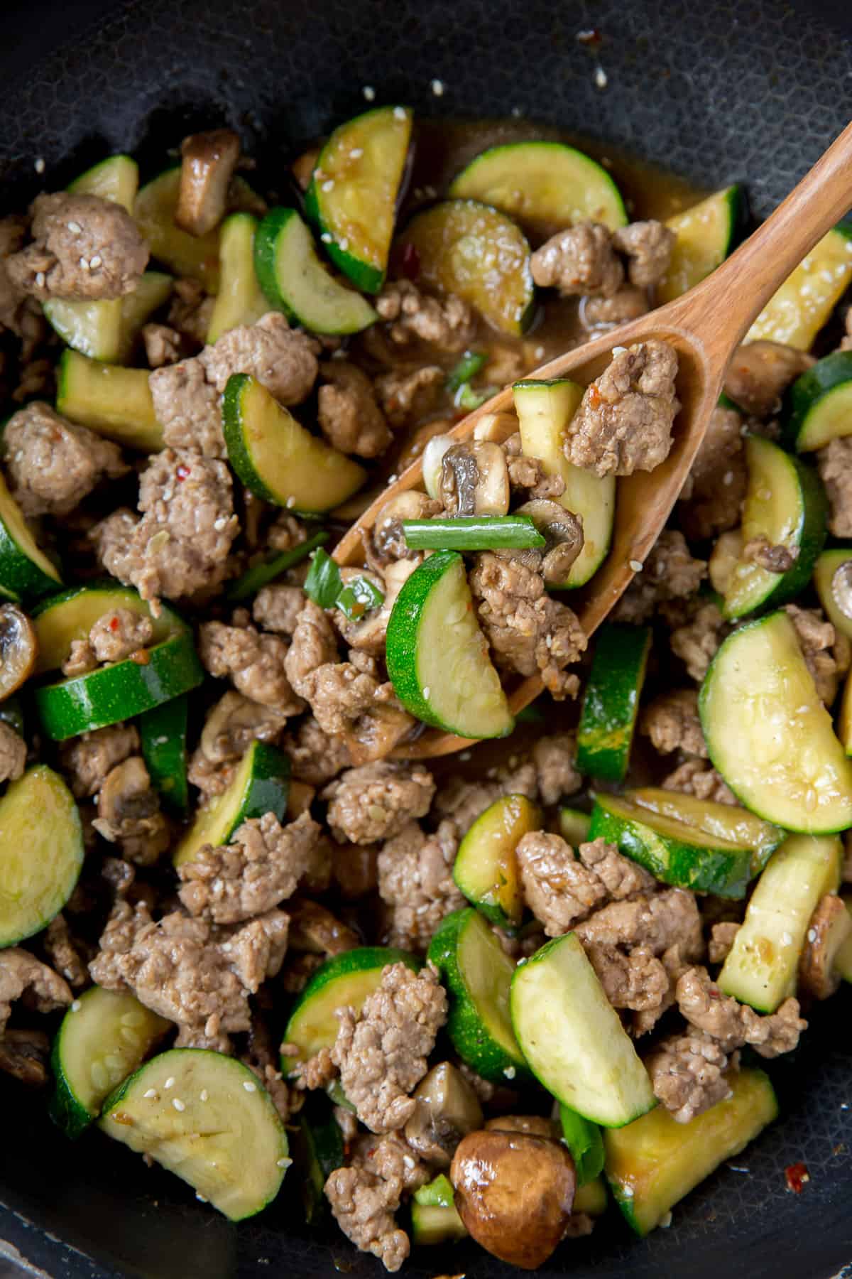 A close up of the ground pork, zucchini, and mushrooms.