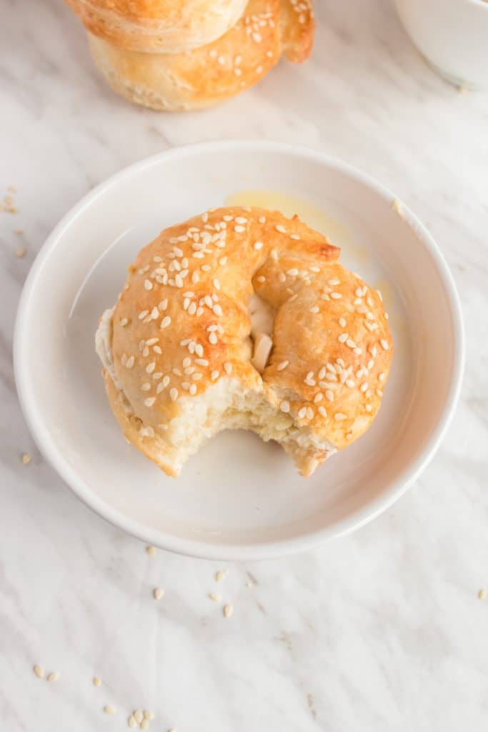 bagel in white plate with a bite missing