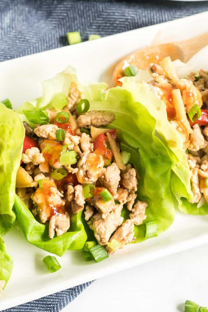 A closeup of the ground chicken mixture nestled in a butter lettuce leaf.