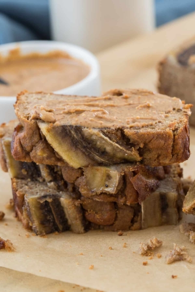 closeup image of sliced banana bread topped with almond butter