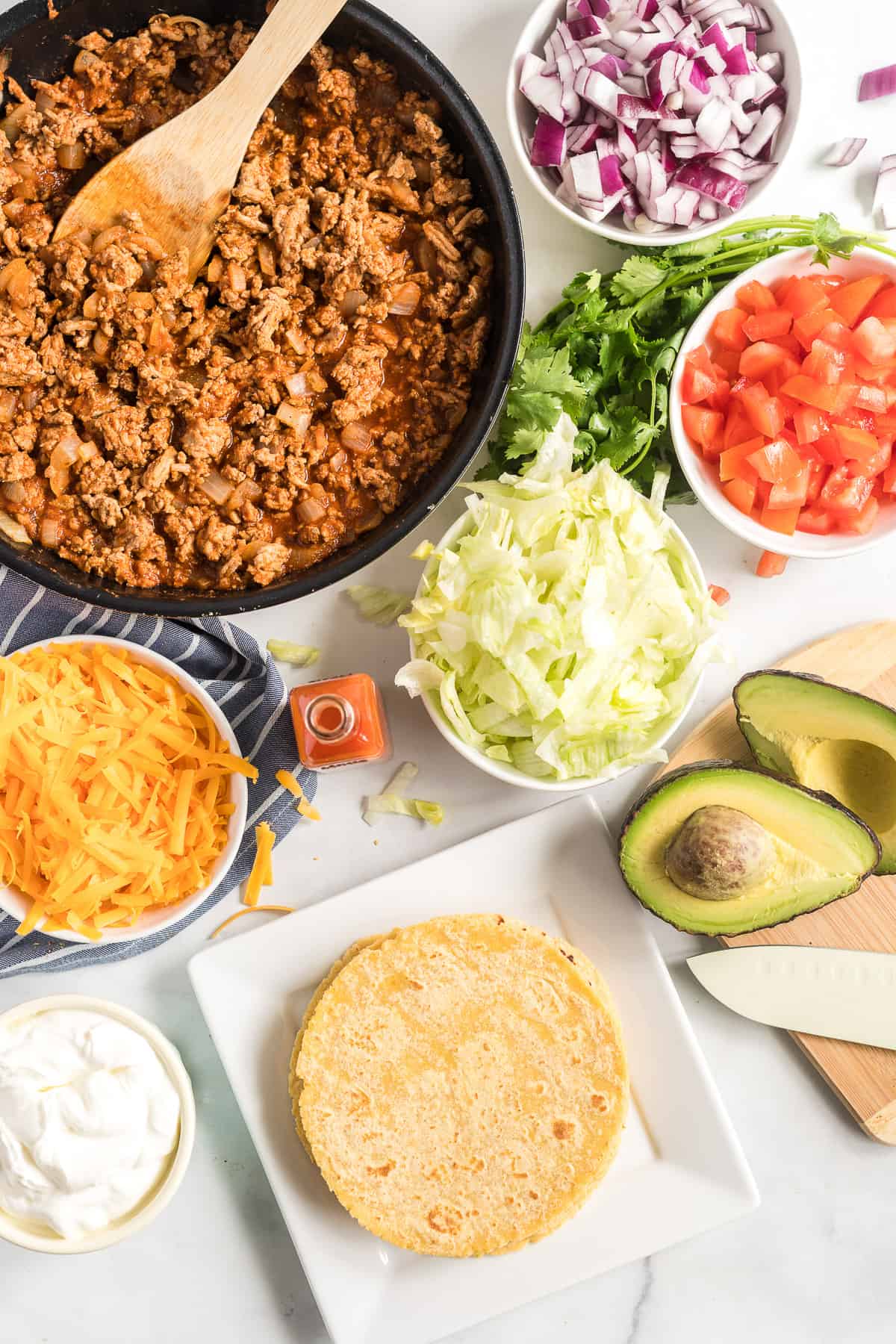 The cooked ground turkey, tortillas and optional toppings.