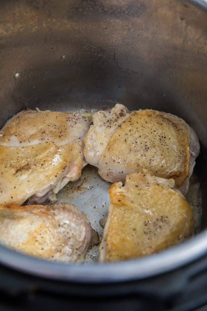 chicken thighs being seared in an Instant Pot