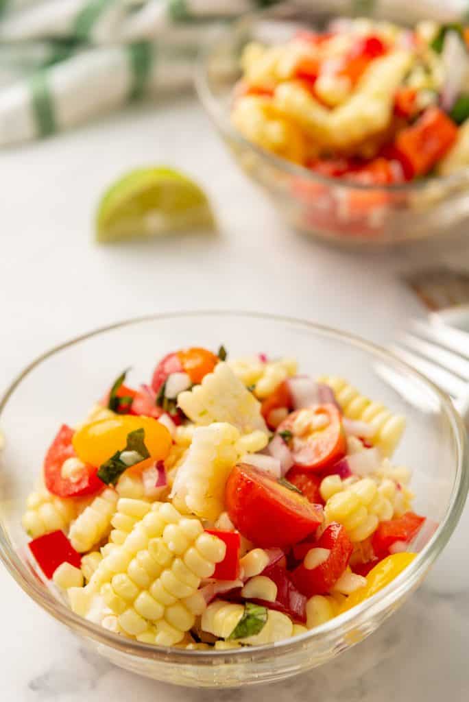 A small glass bowl filled with the corn salad 