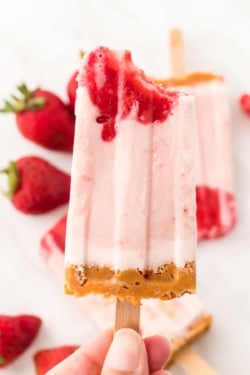strawberry cheesecake popsicle with bite taken out