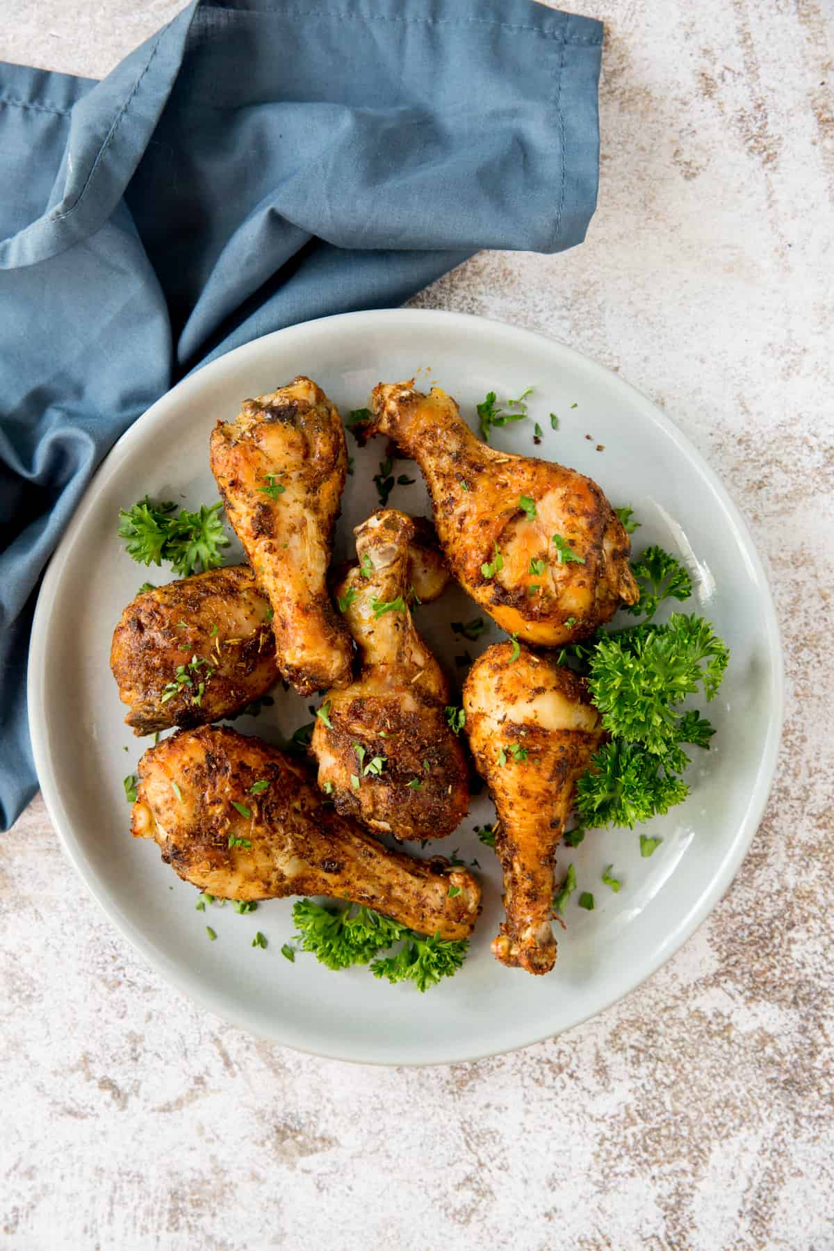 cooked chicken drumsticks on a plate garnished with parsley