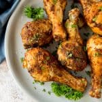 cooked chicken legs on a plate garnished with parsley
