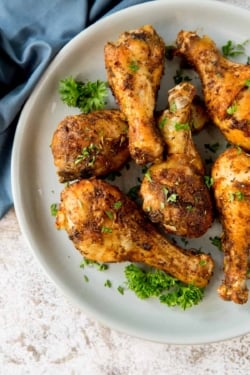 cooked chicken legs on a plate garnished with parsley