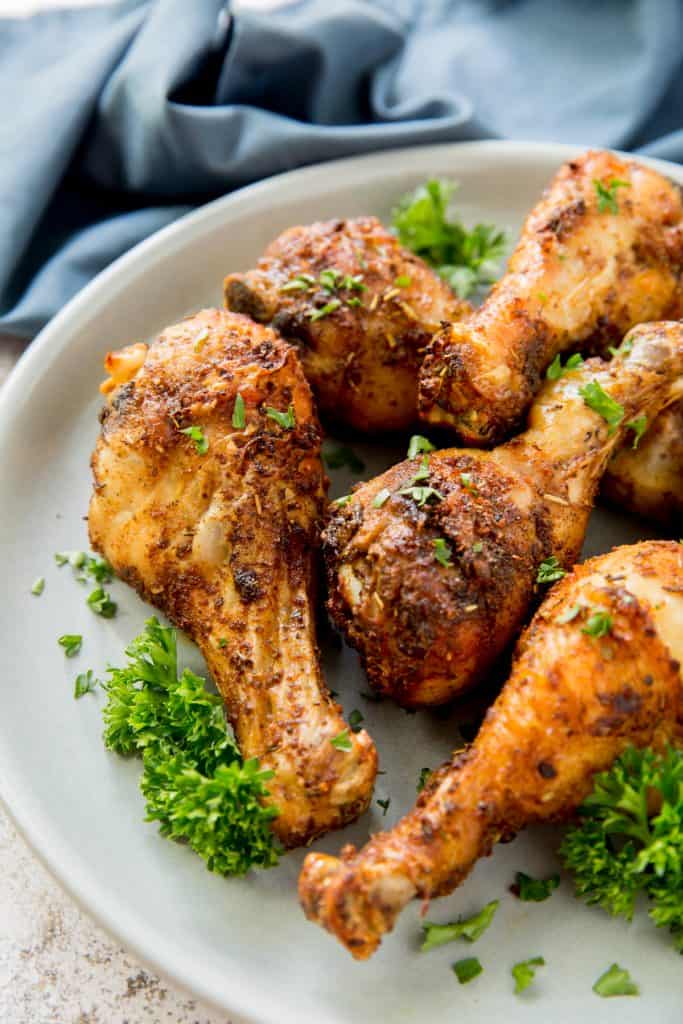 cooked chicken legs on a plate garnished with parsley