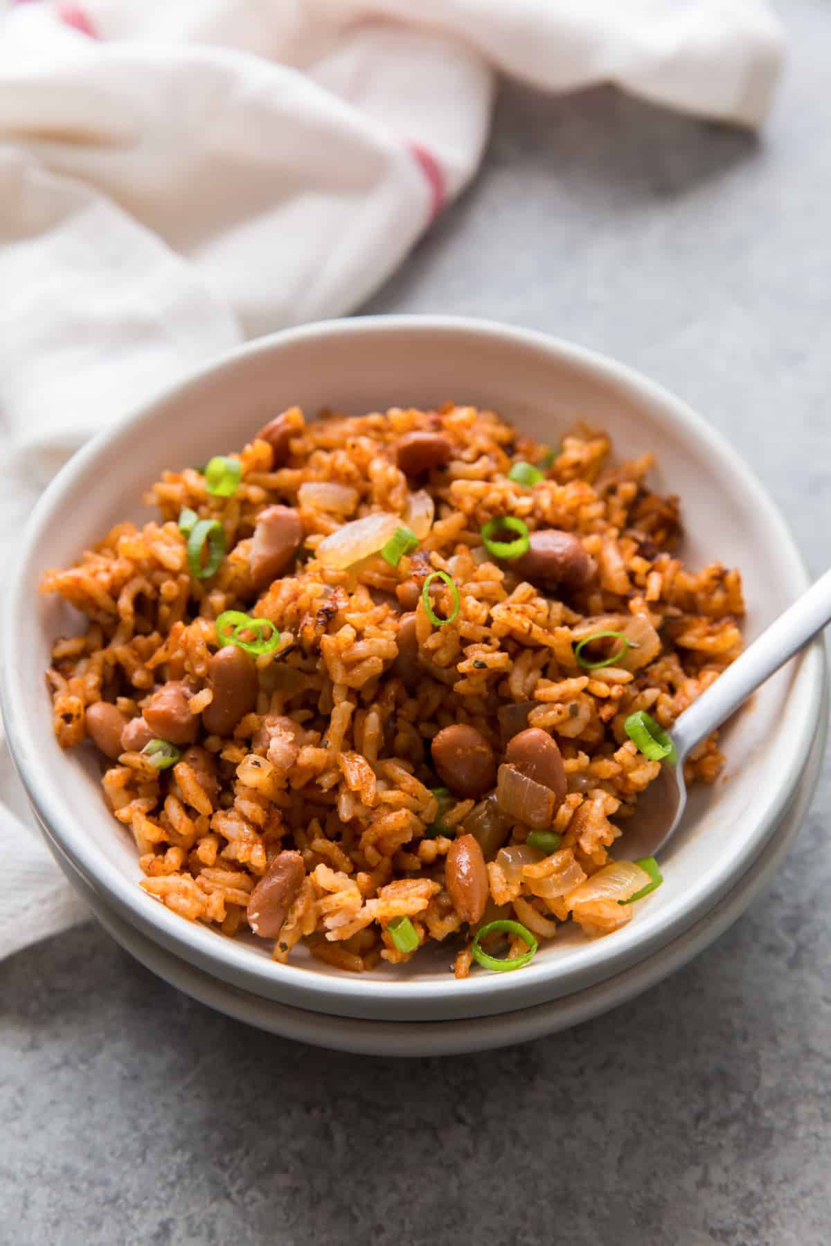 low sodium rice and beans in a white bowl with a spoon and napkin