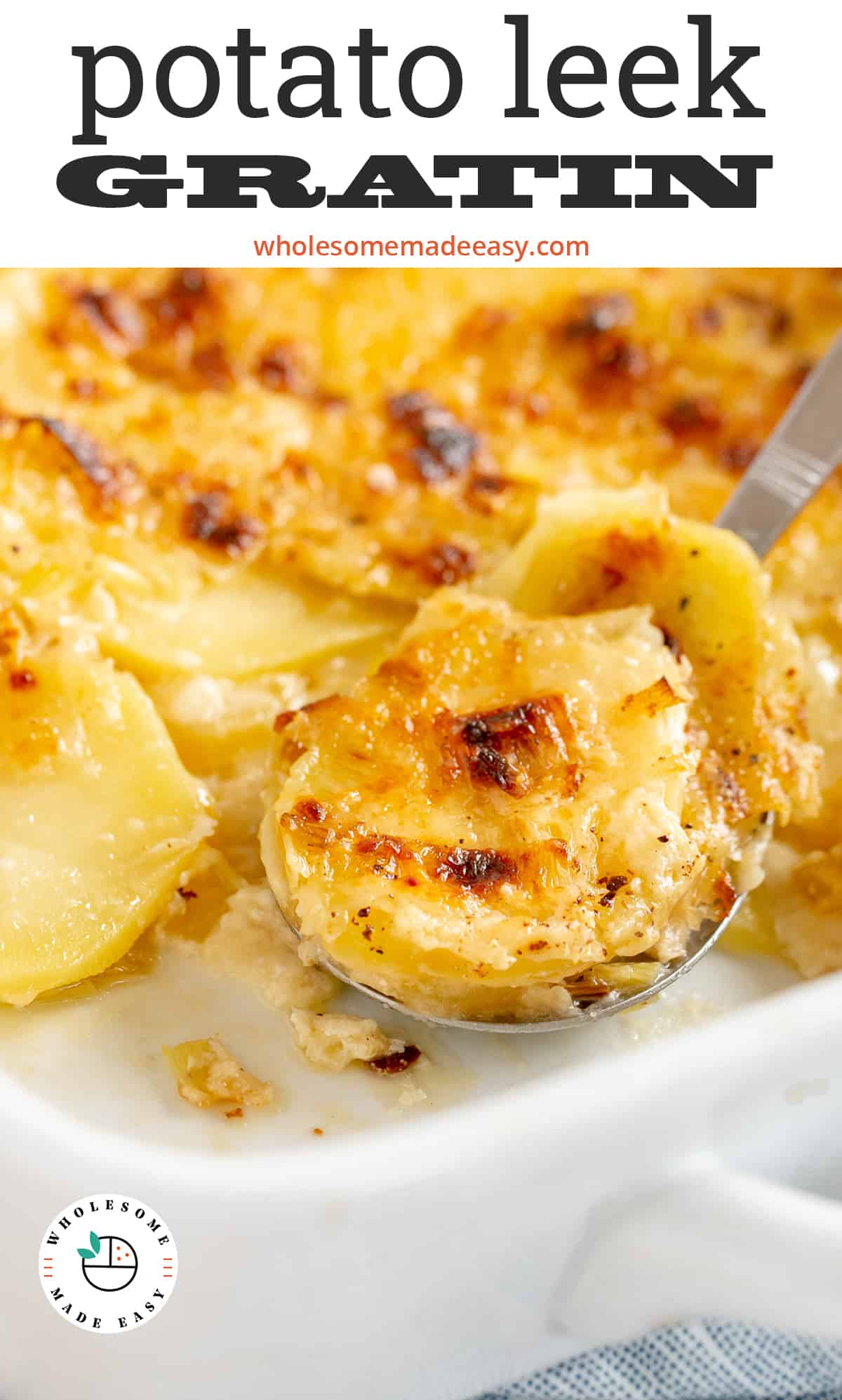 A spoon scoops up some Potato Leek Gratin from a baking dish.