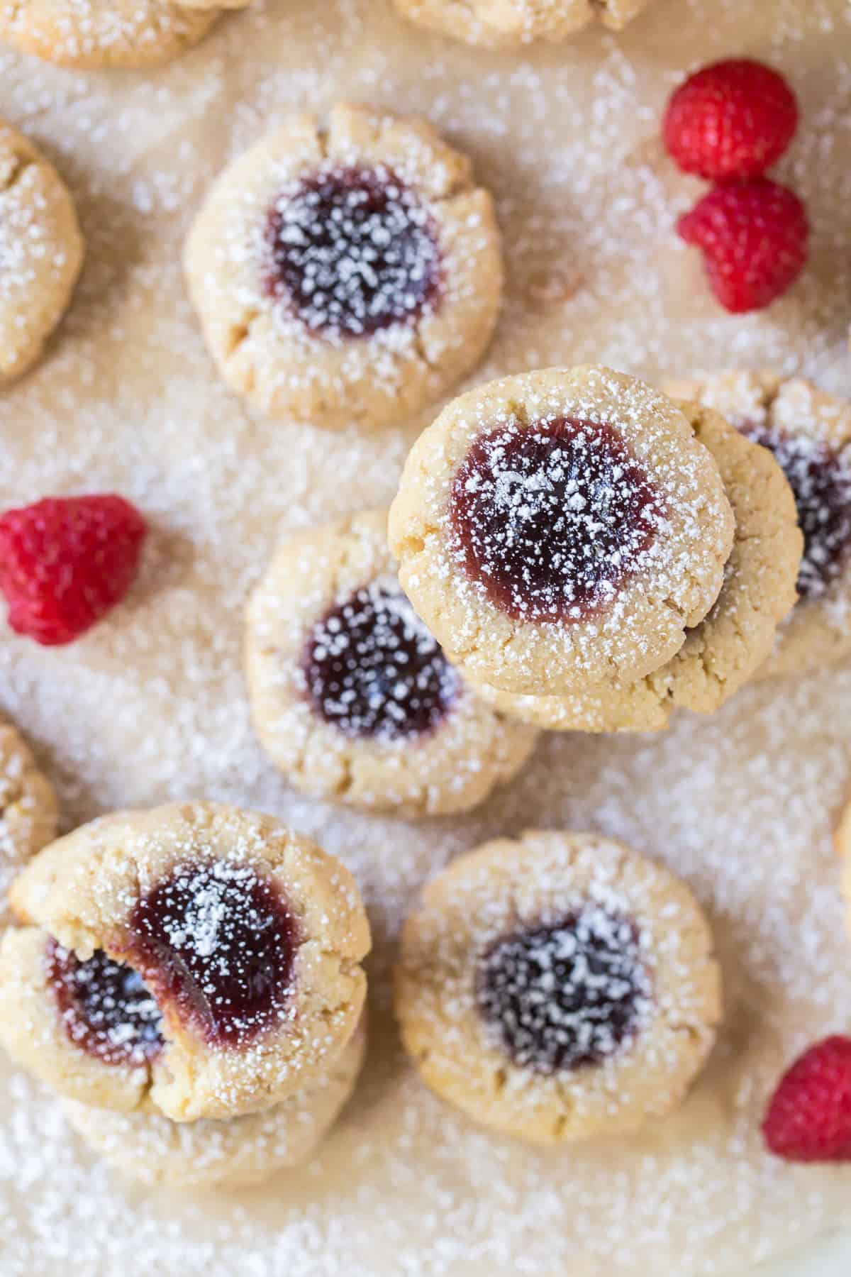 An over the top shot of thumbprint cookies with fresh raspberries.