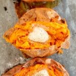 Three baked sweet potatoes topped with butter shot from over the top.