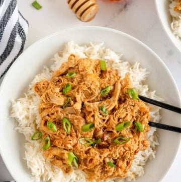 Shredded Honey Soy Chicken over rice with chopsticks.