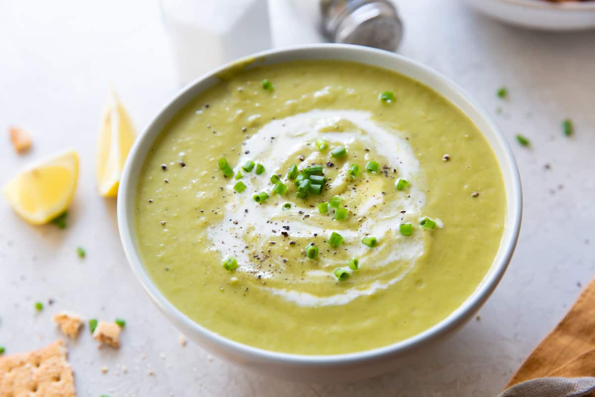A bowl of Asparagus Soup topped with cream and chives.
