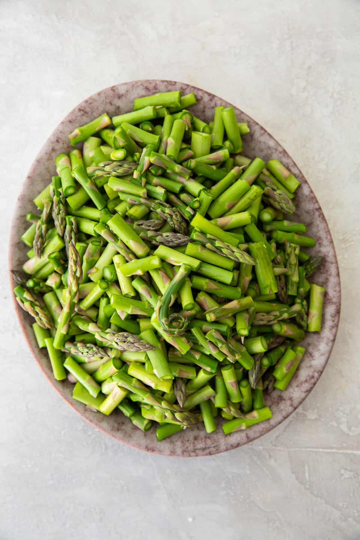 A plate filled with chopped asparagus.