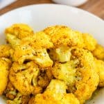 Turmeric Roasted Cauliflower florets in a white bowl.
