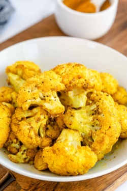 Turmeric Roasted Cauliflower florets in a white bowl.