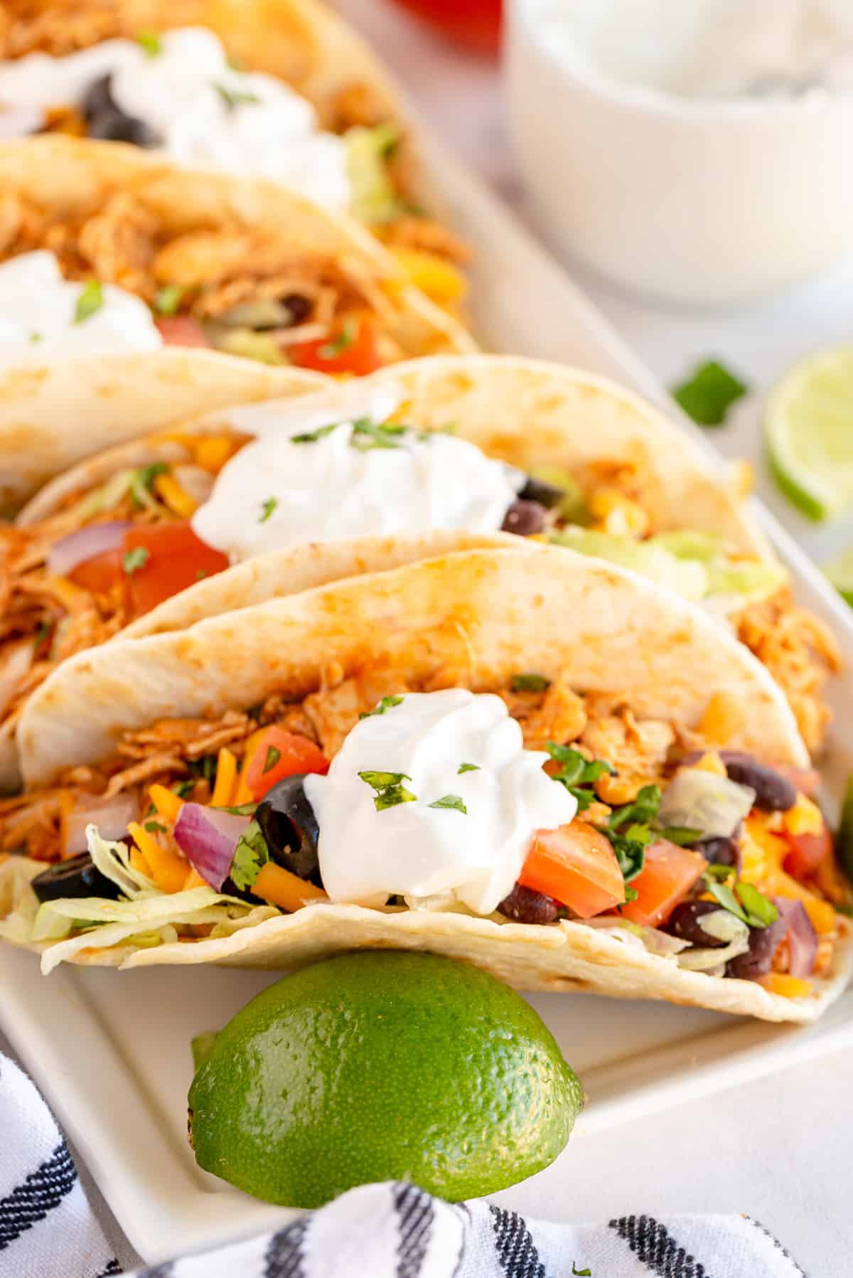 Rotisserie Chicken Tacos on a platter with a lime wedge.