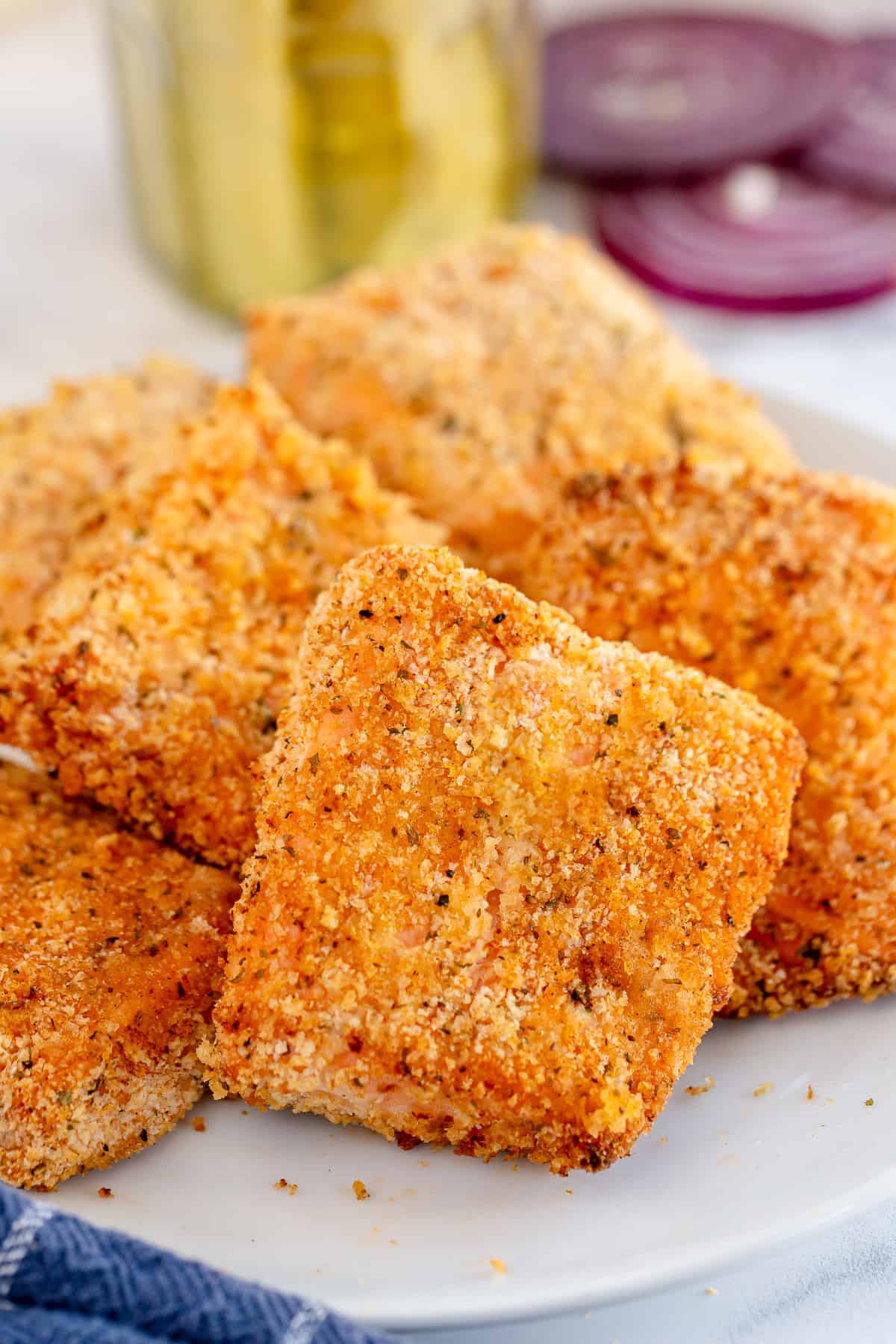 Breaded air fried salmon fillets on a plate.