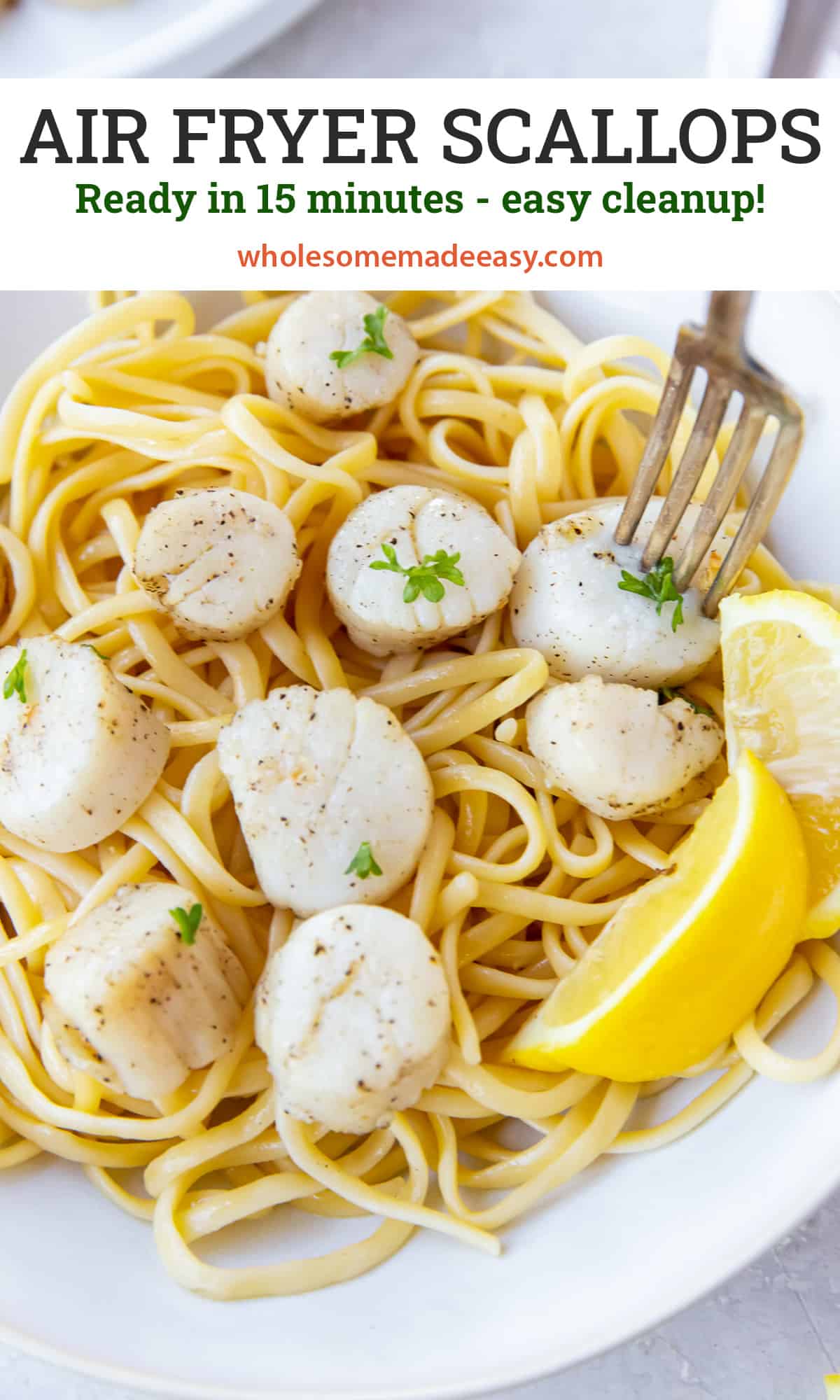 Scallops over pasta with lemon wedges in a white bowl with text.