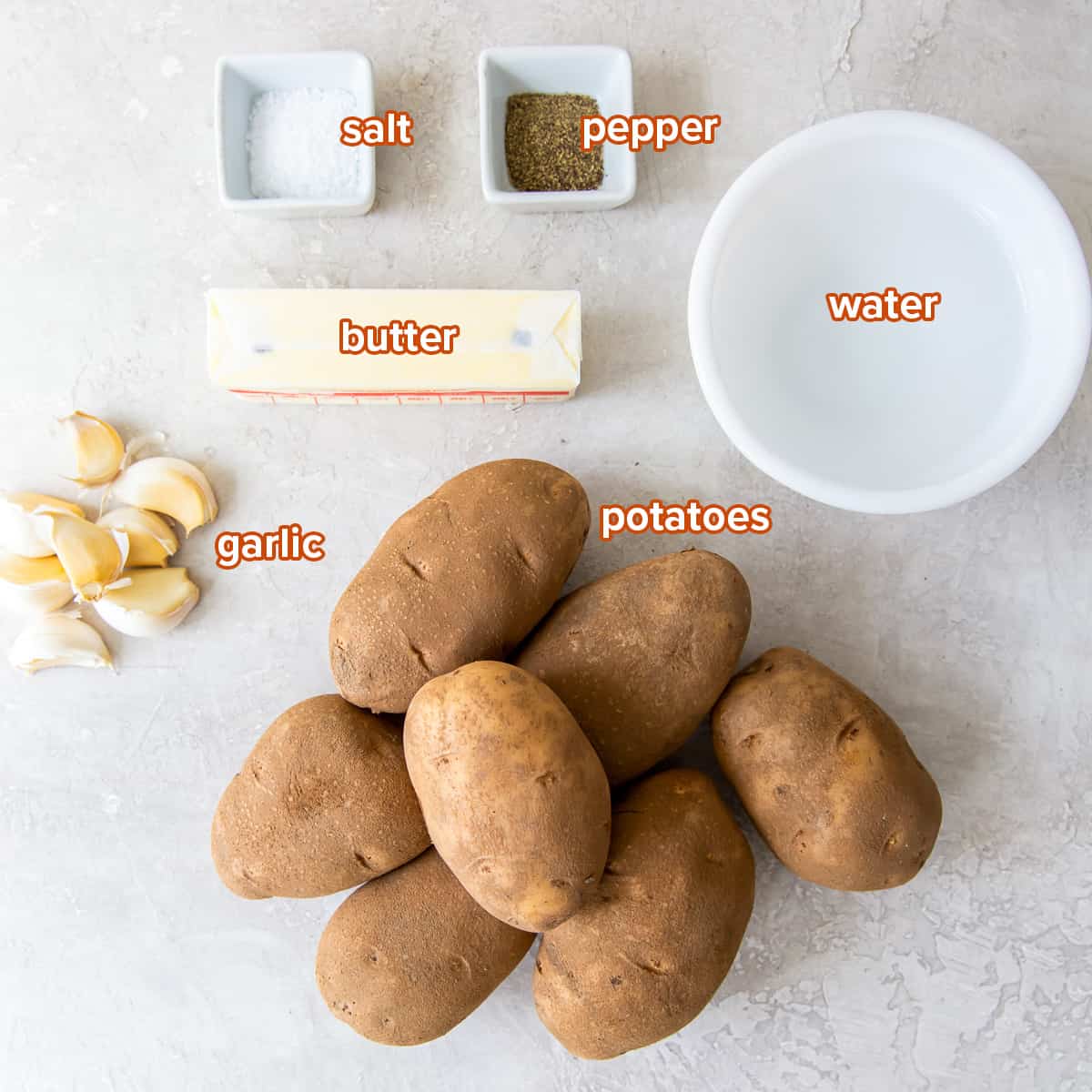 Potatoes, garlic, butter, salt, pepper, and water with text.