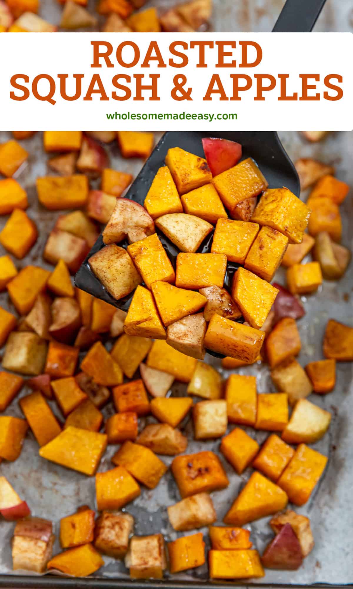 A spatula lifts roasted butternut squash and apples from a baking sheet.