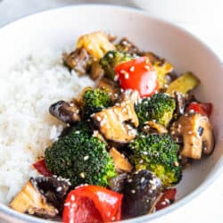 Broccoli mushroom stir fry in a bowl with white rice.