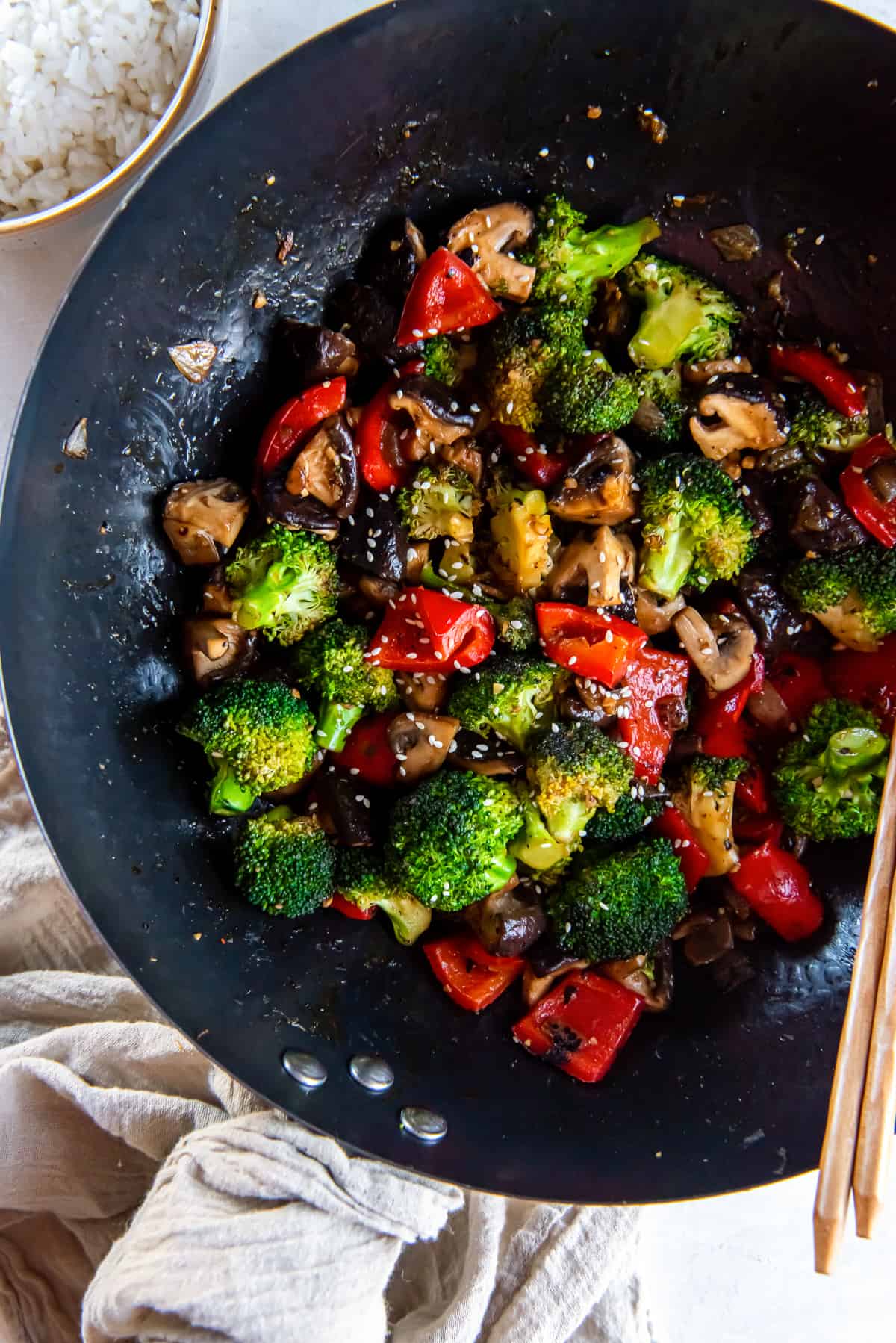 Colorful stir fried vegetables in a wok with chopsticks.