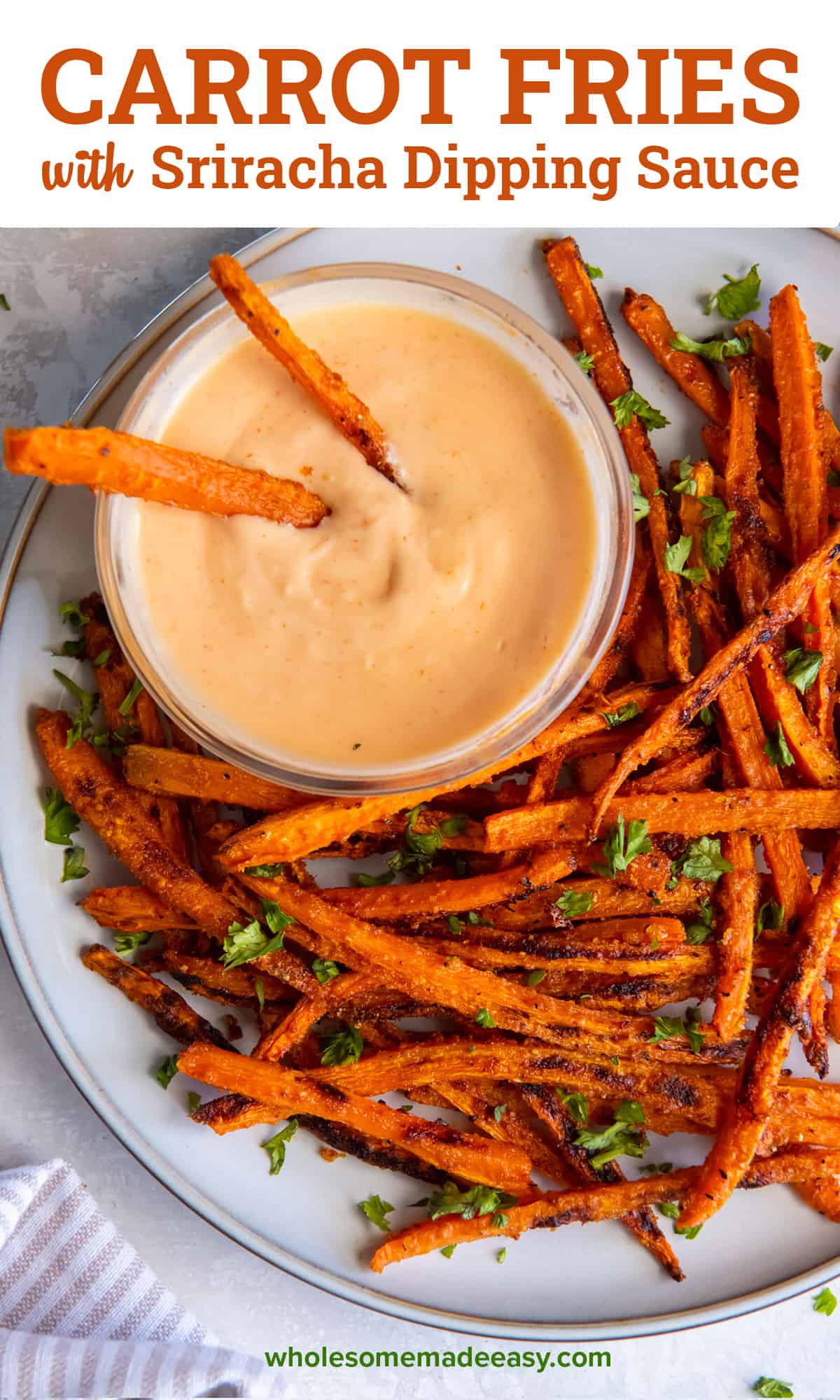 Two carrot fries resting in a bowl on sriacha dipping sauce on a white plate with text.