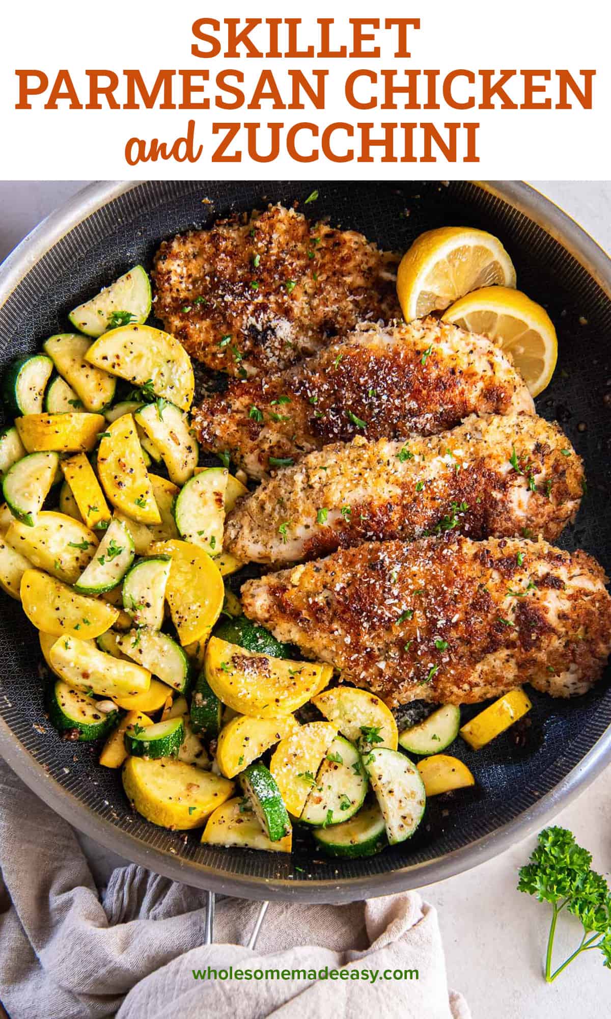 Crispy chicken in a skillet with green and yellow zucchini and lemon slices with text.