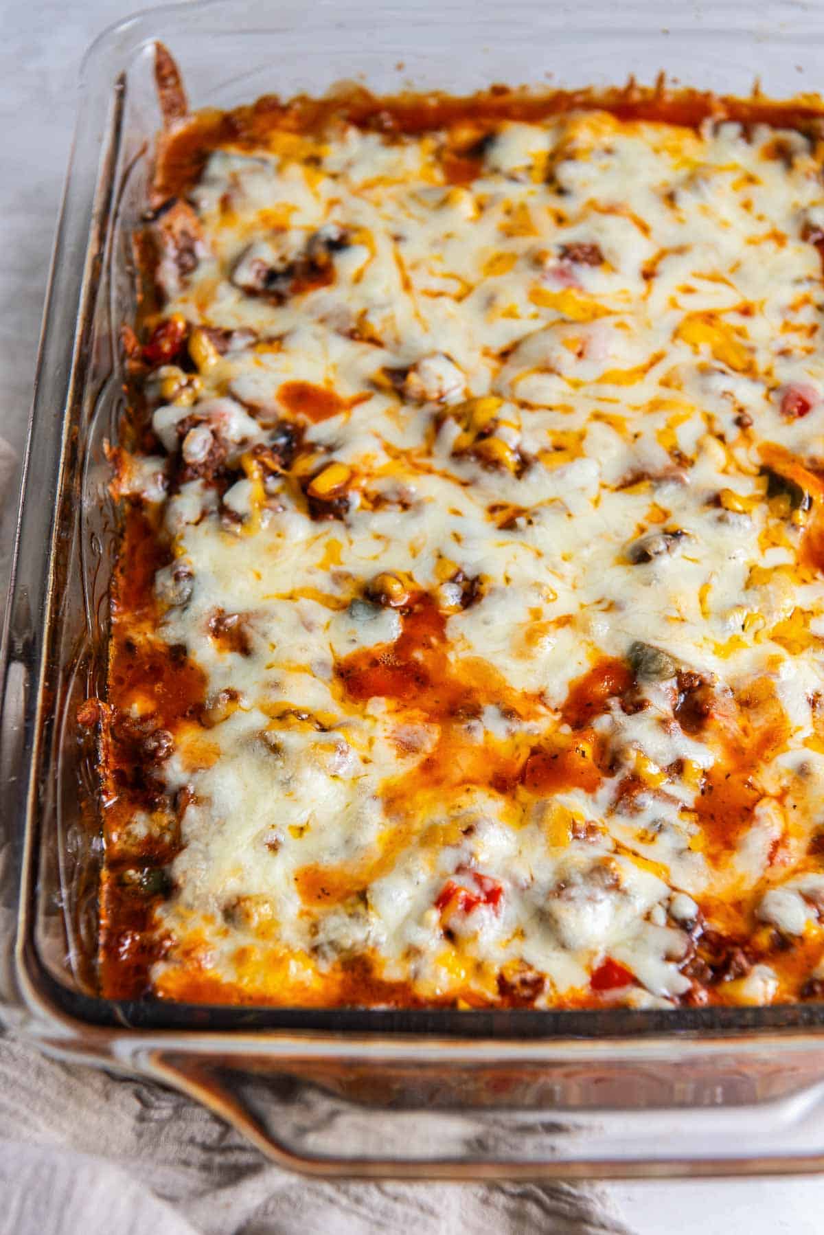 Zucchini pizza casserole with melted cheese in a baking dish.