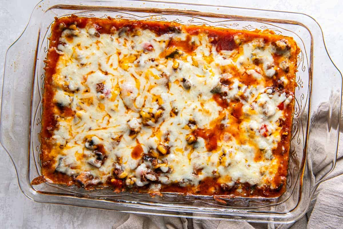 Cheesy zucchini pizza casserole in a baking dish.