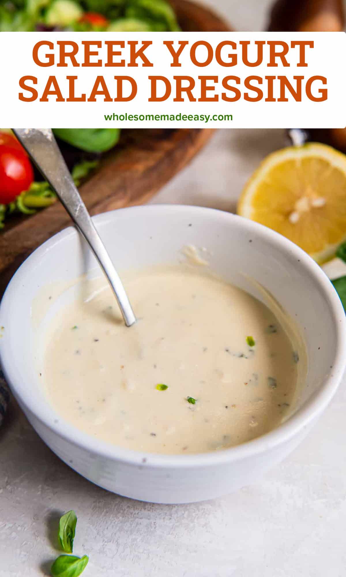 Greek yogurt salad dressing in a bowl with a spoon in front of a green salad with text overlay.