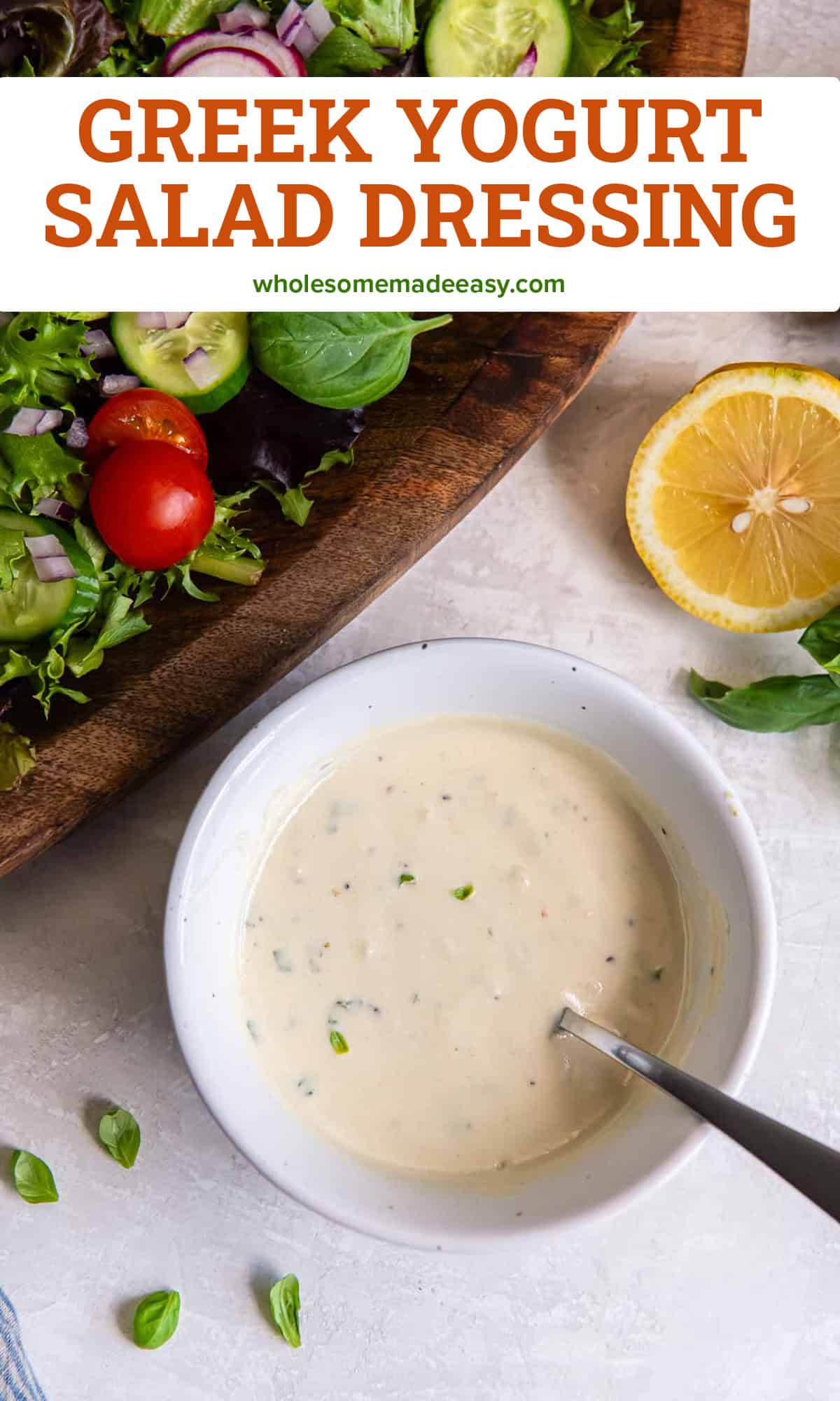 Greek yogurt salad dressing in a bowl with a spoon next to a salad and a lemon half with text overlay.