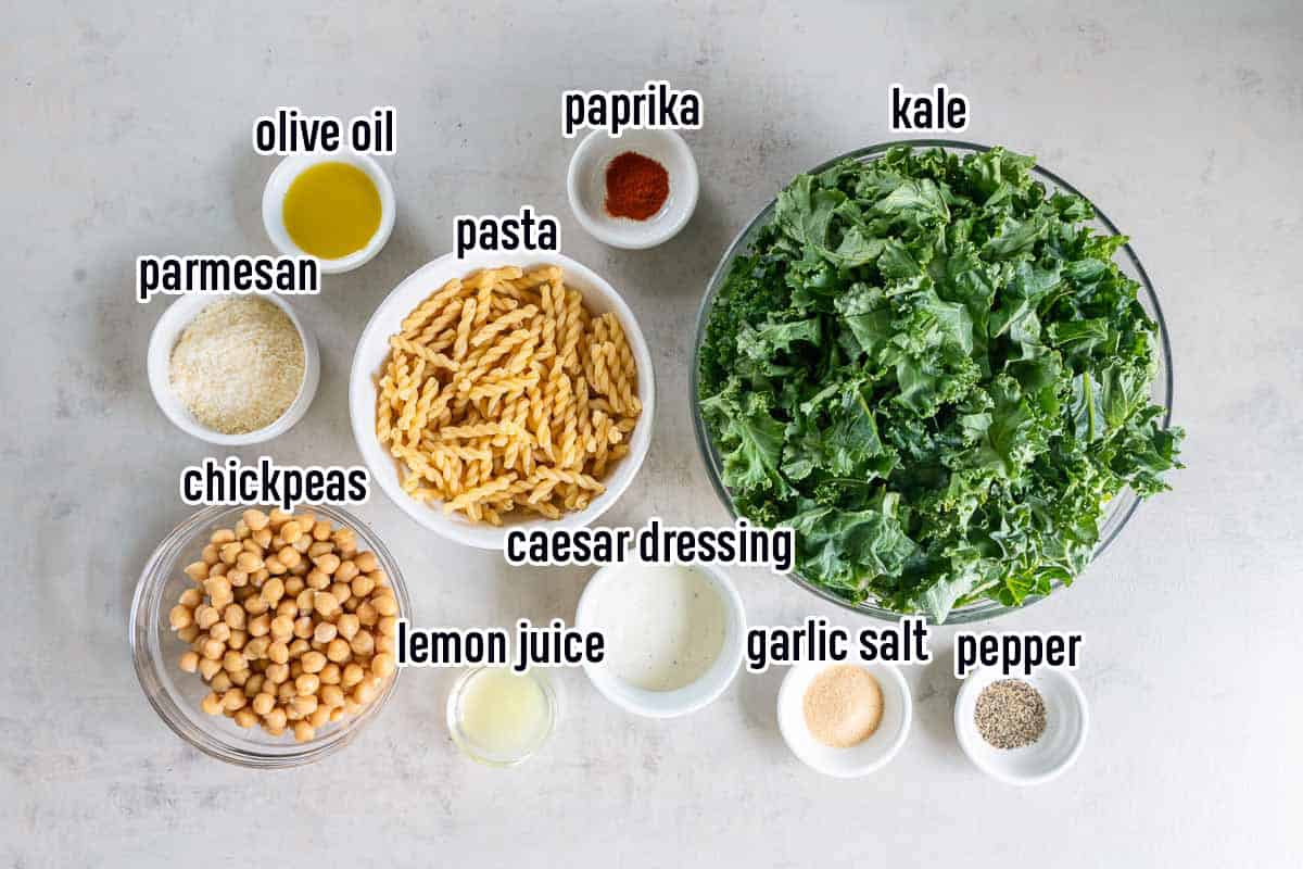 Kale, chickpeas, caesar dressing and other ingredients in bowls with text overlay.