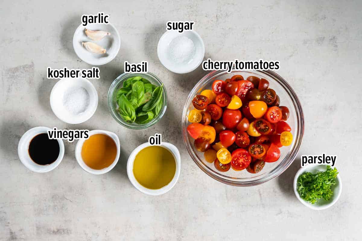 Cherry tomatoes, oil, vinegar and other ingredients in bowls with text overlay.