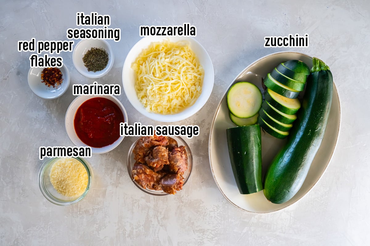 Sliced zucchini, parmesan cheese, marinara, and other ingredients in bowl with text overlay.