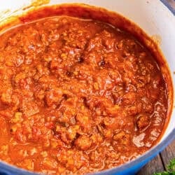 Chicken Bolognese in a blue Dutch oven, rich tomato sauce with ground chicken and vegetables.