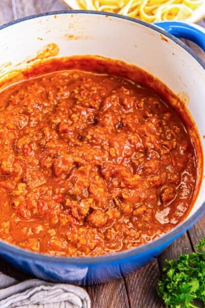 Chicken Bolognese in a blue Dutch oven, rich tomato sauce with ground chicken and vegetables.