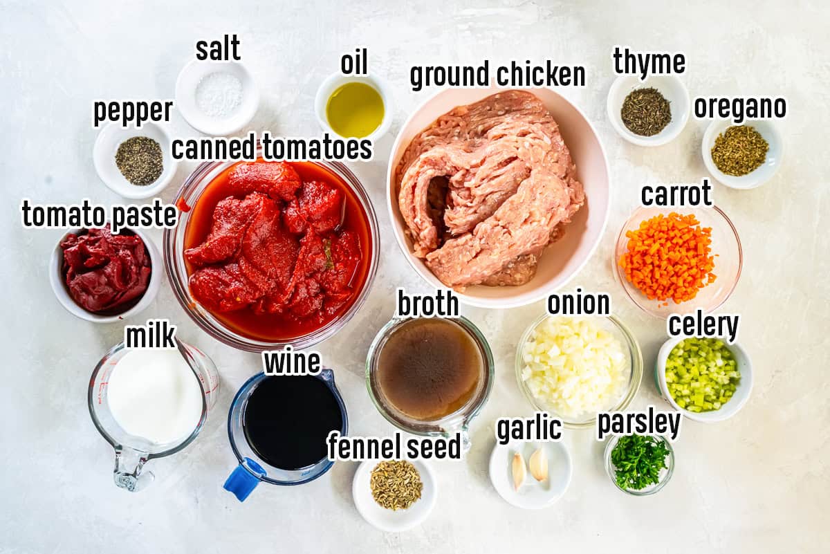 Chicken bolognese ingredients including ground chicken, canned tomatoes and more in bowls with text overlay.