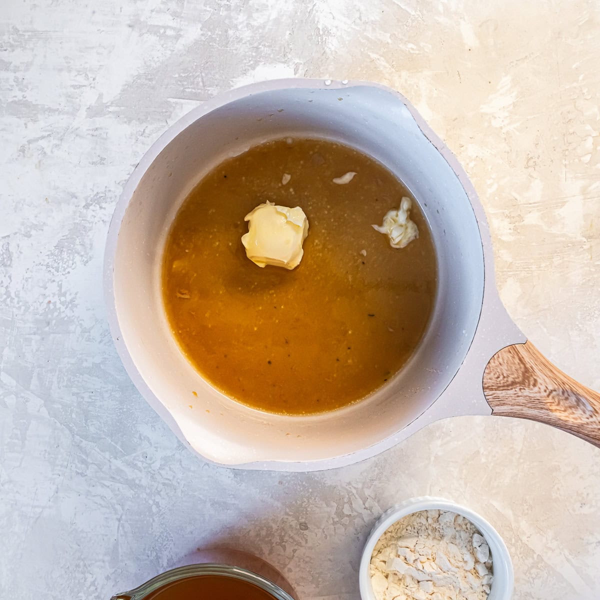 Butter added to simmering turkey gravy in a saucepan to finish and enrich the sauce.