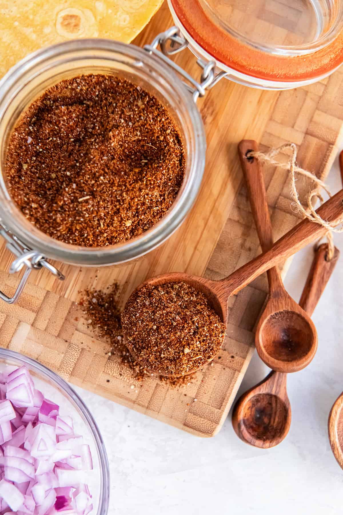 a glass jar of homemade low sodium taco seasoning with a spoonful of seasoning