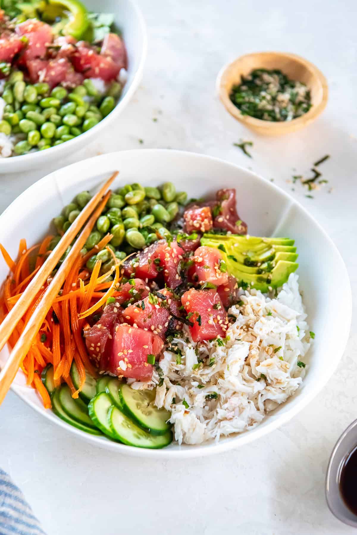 Ahi tuna poke bowl with marinated ahi tuna, crab meat, avocado, cucumber, shredded carrot, and edamame served over white rice.