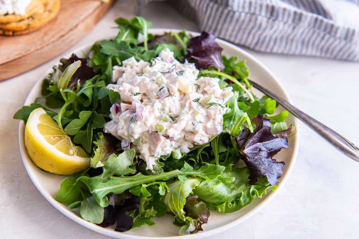 Cottage cheese chicken salad served over mixed greens with a lemon wedge.