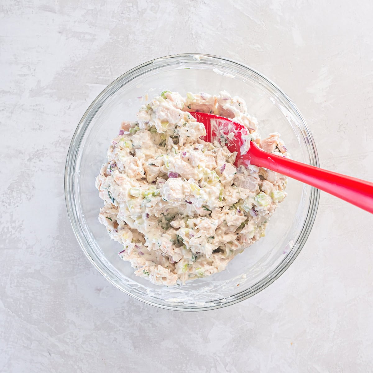 Cottage cheese chicken salad in a bowl with a rubber spatula.