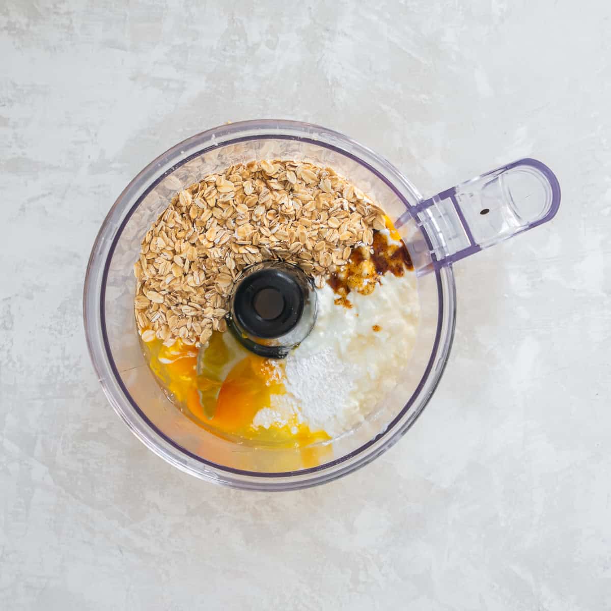 Ingredients for cottage cheese pancakes added to a food processor before blending.