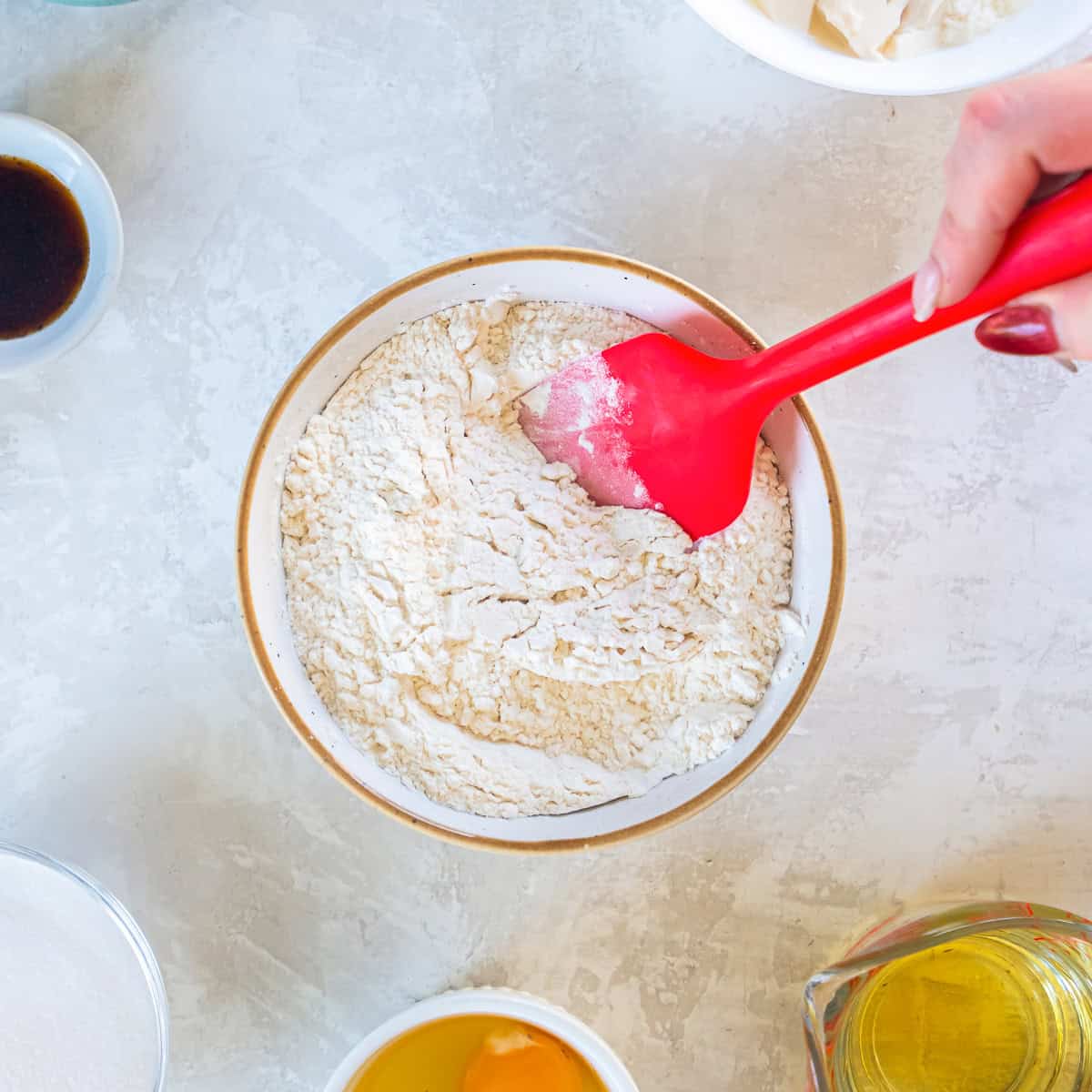 Flour mixture for blueberry muffins being stirred together in a bowl.