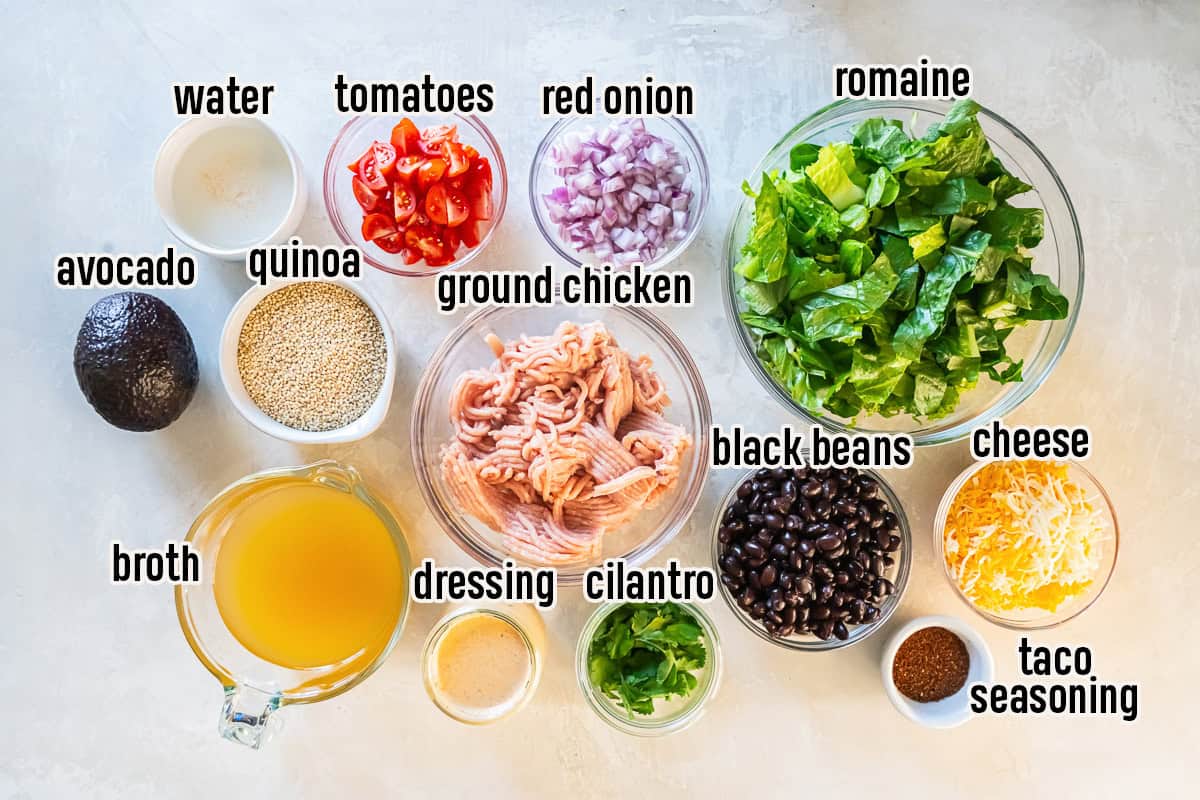 Ingredients for Chicken Taco Grain Bowls including ground chicken, quinoa, romaine, black beans, cherry tomatoes, red onion, cilantro, avocado, cheese, taco seasoning, broth, water, and creamy cilantro lime dressing.