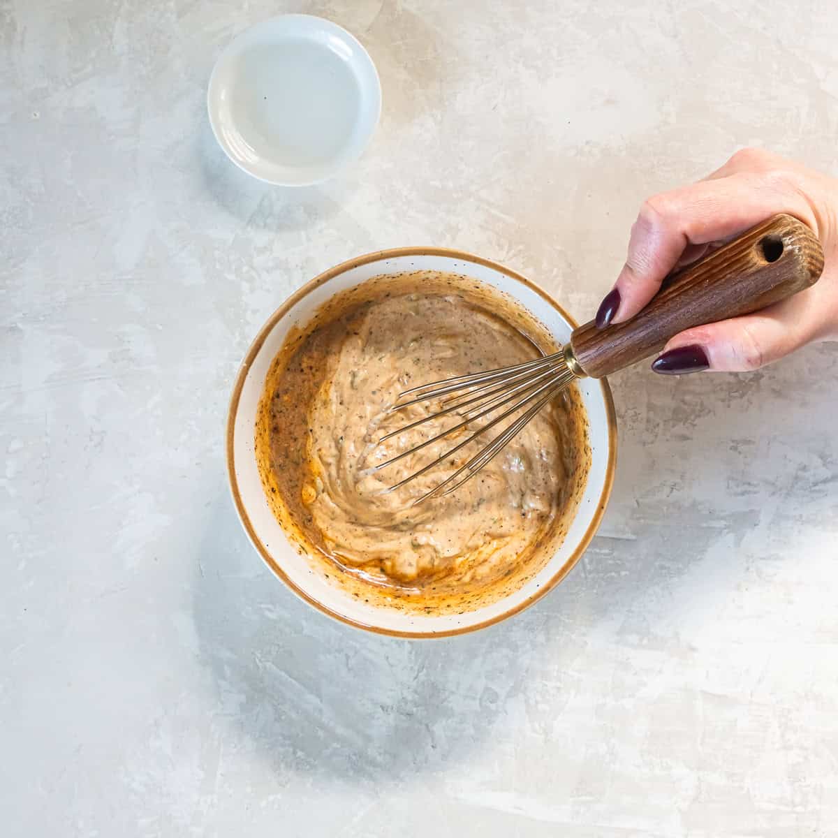 Whisking creamy cilantro lime dressing ingredients together in a bowl until smooth.